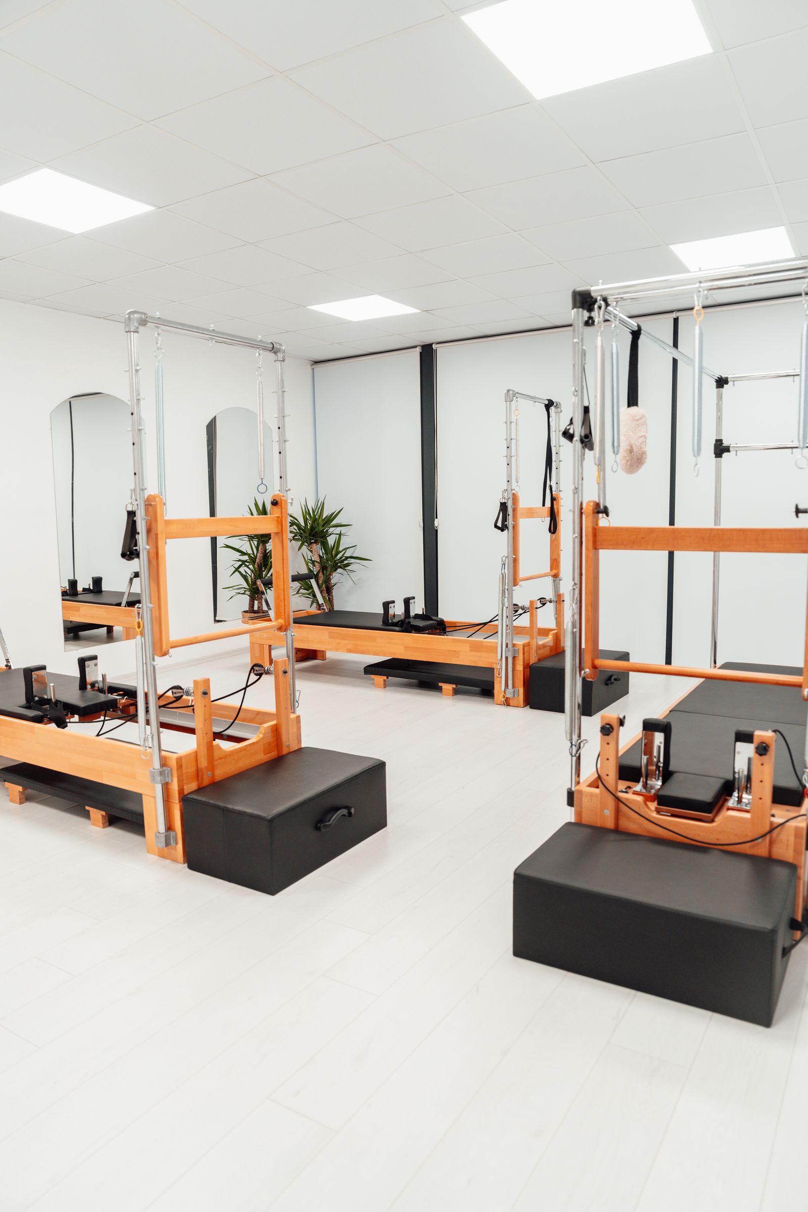Sala luminosa con máquinas de pilates reformer y torre
