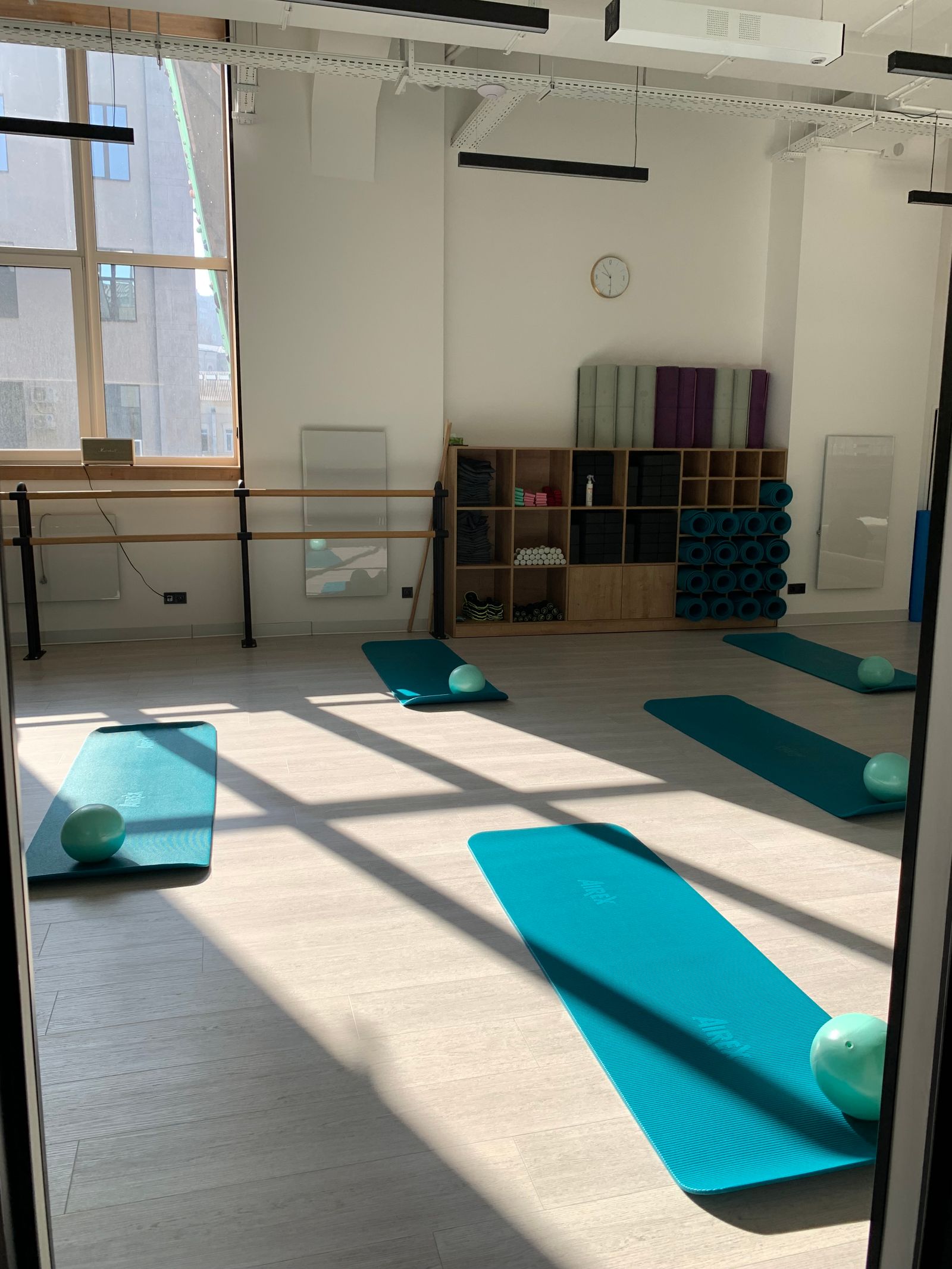 Sala de clases con esterillas preparadas y luz de la ventana