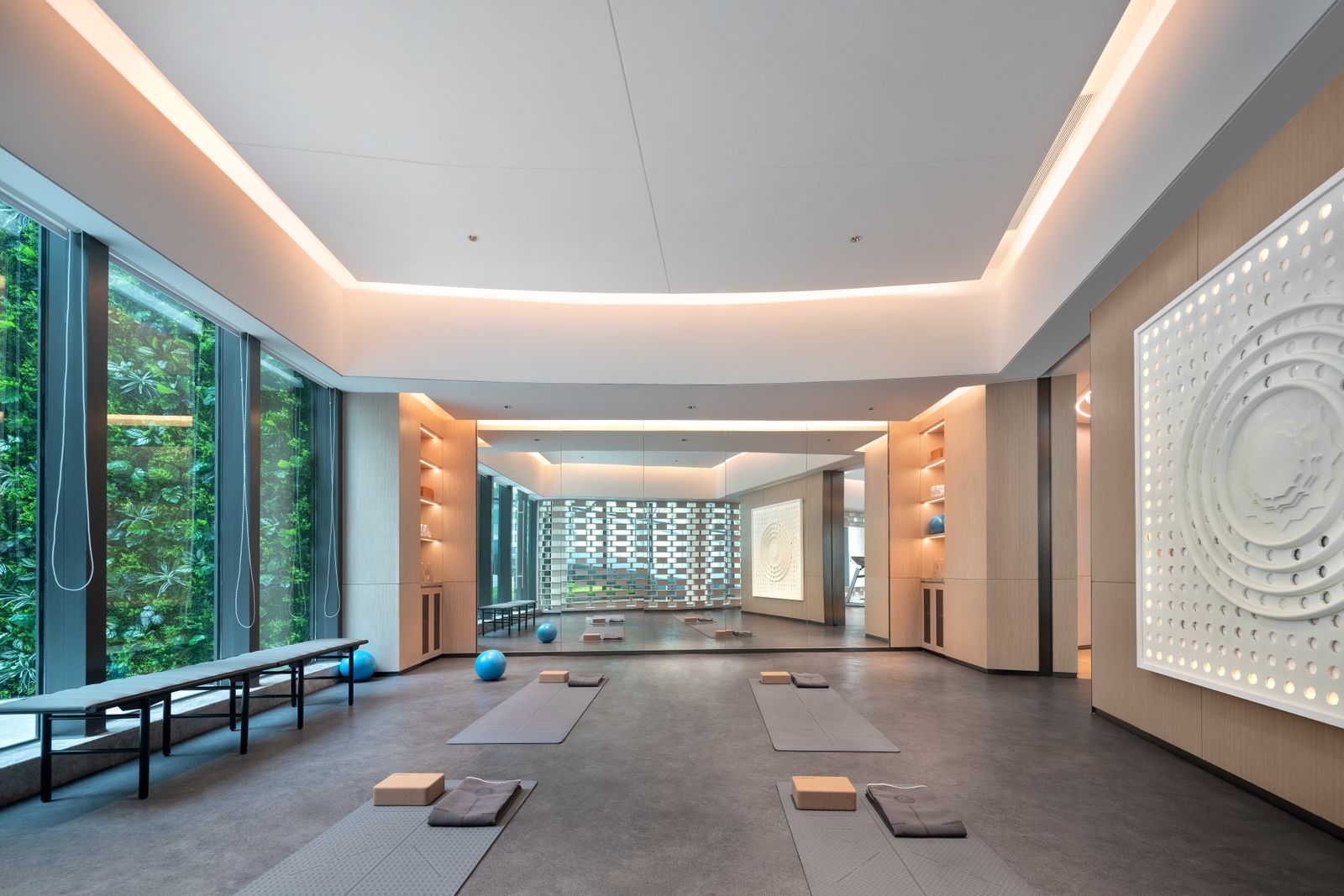 Sala luminosa de yoga con esterillas y jardín vertical